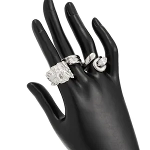 Detailed view of four silver-tone irregular textured rings with sparkling marquise zircons