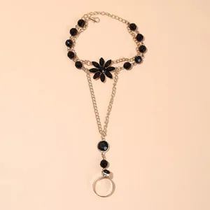 Détail de la chaîne de main vintage avec pétales de lotus noirs et métal doré