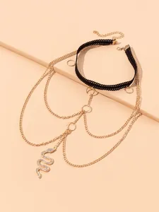 Detail van boheemse dijketting met gouden kwastjes en een sprankelende slangenhanger