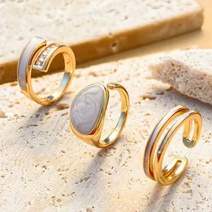Detail of gold geometric rings with enamel inlay and zircon on travertine stone