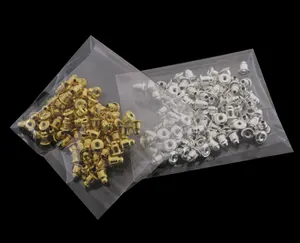 Macro shot of bulk golden and silver bullet metal earring backs in transparent packaging
