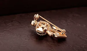 Macro detail showing the golden crown brooch back with a secure long needle and ball clasp