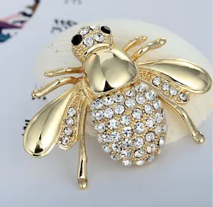 Detailed macro shot of golden bee brooch with sparkling rhinestones on shell