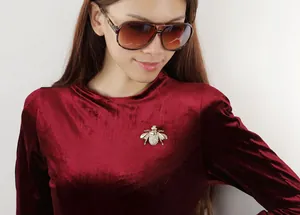 Exquisite golden honey bee brooch with sparkling rhinestones on a velvet jacket