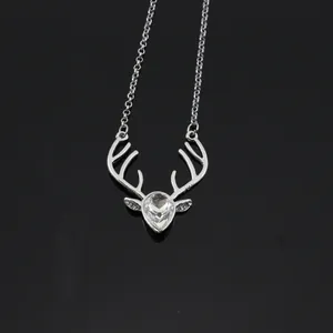 Macro shot of silver deer antler necklace pendant with crystal drop and rhinestone accents