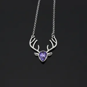 Detailed view of silver deer antler necklace featuring a purple teardrop crystal