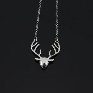 Macro shot of silver deer head pendant with crystal accents on a sleek metal chain