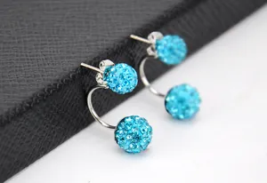 Dettaglio macro di orecchini a doppia sfera in cristallo azzurro con design a C argento
