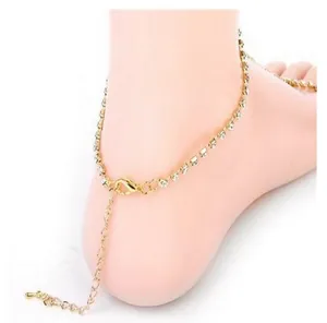 Detail of adjustable gold rhinestone anklet with lobster clasp on white background