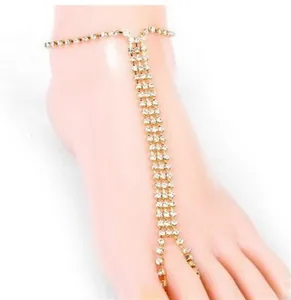 Detailed close-up of a golden rhinestone anklet featuring three-row crystal chains
