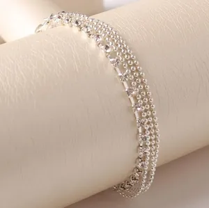 Fashionable multi-layer silver anklet with rhinestone chains on a jewelry display