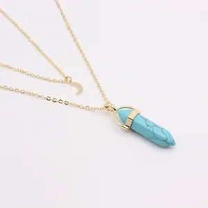 Détail du collier double rang doré avec lune et pendentif en pierre hexagonale bleue