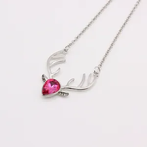 Close-up of deer antler necklace with a large rose red teardrop crystal stone