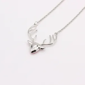 Close-up of a silver deer head pendant with red detail on an elegant O-chain necklace