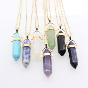 Détail de sept pendentifs en cristal hexagonal avec colliers dorés et pierres minérales