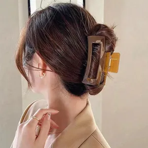 Grote amberbruine vierkante haarklem gedragen op een model voor een chique updo-stijl