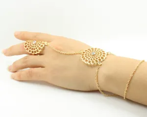 Detail of gold finger bracelet with hollow fan-shaped flowers and sparkling crystals