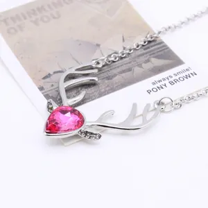 Detail of silver reindeer antler necklace with a pink heart-shaped crystal centerpiece