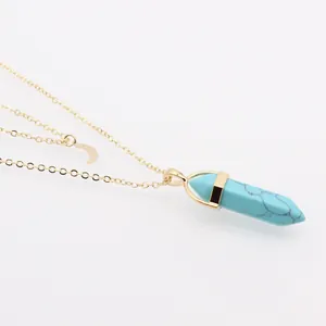Vue détaillée du pendentif hexagonal en turquoise et du collier doré en forme de lune