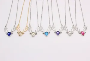 Flat lay of crystal reindeer necklaces in seven vibrant colors and metallic finishes
