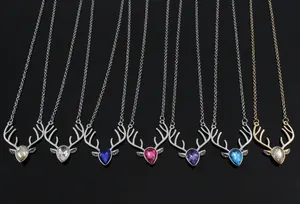 Macro shot of stag antler crystal necklaces in seven vivid colors on black reflective background