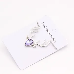 Detail of silver stag head necklace with purple teardrop crystal and small diamonds