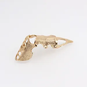 Close-up of golden punk armor finger ring with hollowed heart patterns and textured finish
