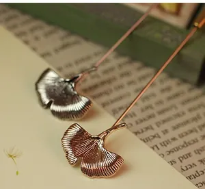 Macro detail of elegant ginkgo leaf brooches in gold and silver with fine vein textures
