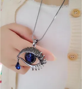 Dettaglio del ciondolo a occhio di cristallo con goccia blu su catena a serpente