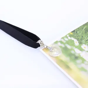 Detail of heart crystal pendant on a black velvet choker necklace with daisy card