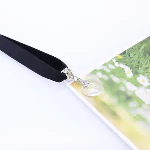 Detailed view of a black velvet choker with a transparent crystal heart pendant