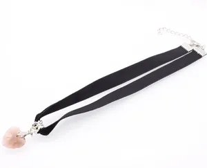 Close-up of black velvet choker featuring a transparent pink crystal heart pendant