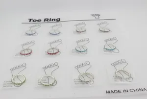 Macro shot of a 12-piece set of colorful crystal toe rings on white display cards