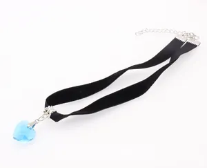 Detailed macro view of heart-shaped blue crystal pendant on black velvet choker necklace