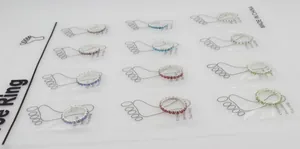 Macro view of crystal toe rings in assorted colors on a white display card pack