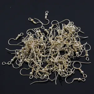 Ganchos dorados para pendientes DIY con resorte y cuenta para bisutería sobre fondo negro
