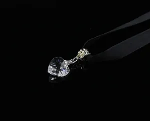 Close-up of faceted crystal heart pendant on a black velvet choker with elegant reflection