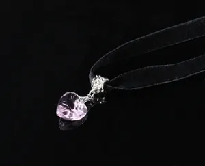 Detail of pink crystal heart pendant on black velvet choker with silver metal connector