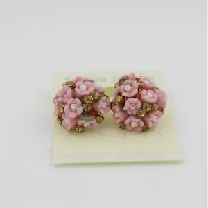 Fashionable pink ceramic flower stud earrings with yellow rhinestones on display card