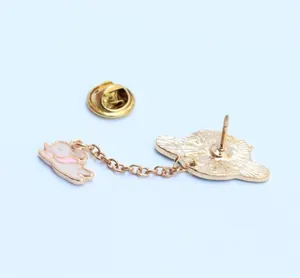 Detalle del dorso del broche de esmalte dorado con estructura de aguja y cierre de mariposa