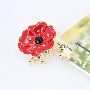 Elegant red enamel poppy flower brooch with gold plating and sparkling crystals on white