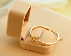 Close-up of golden hollow rose crystal bracelet on a beige velvet jewelry box