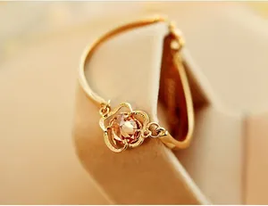 Close-up of golden hollow rose bracelet with amber crystal on velvet jewelry stand