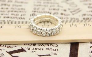 Macro shot of double row sparkling silver rhinestone stretch ring on a wooden ruler