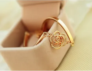 Macro view of gold rose bracelet with a sparkling center crystal and hollow petals