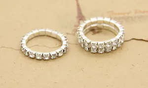 Macro detail of single and double row silver rhinestone elastic rings on vintage paper