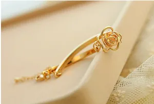 Detailed macro view of a golden hollow rose bracelet with amber gemstone and adjustable chain