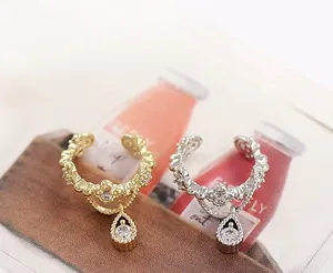 Detalle de pendientes de corona con circonitas y colgantes de cristal de gota