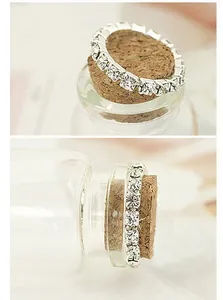 Detailed macro shot of silver elastic rhinestone ring on a cork stopper in a soft light