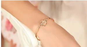 Detailed close-up of a rose gold hollow flower bracelet on a female wrist